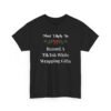 Unisex t-shirt from Twisted Angell with the sarcastic phrase “Most Likely To Record A TikTok While Wrapping Gifts” printed on the front.